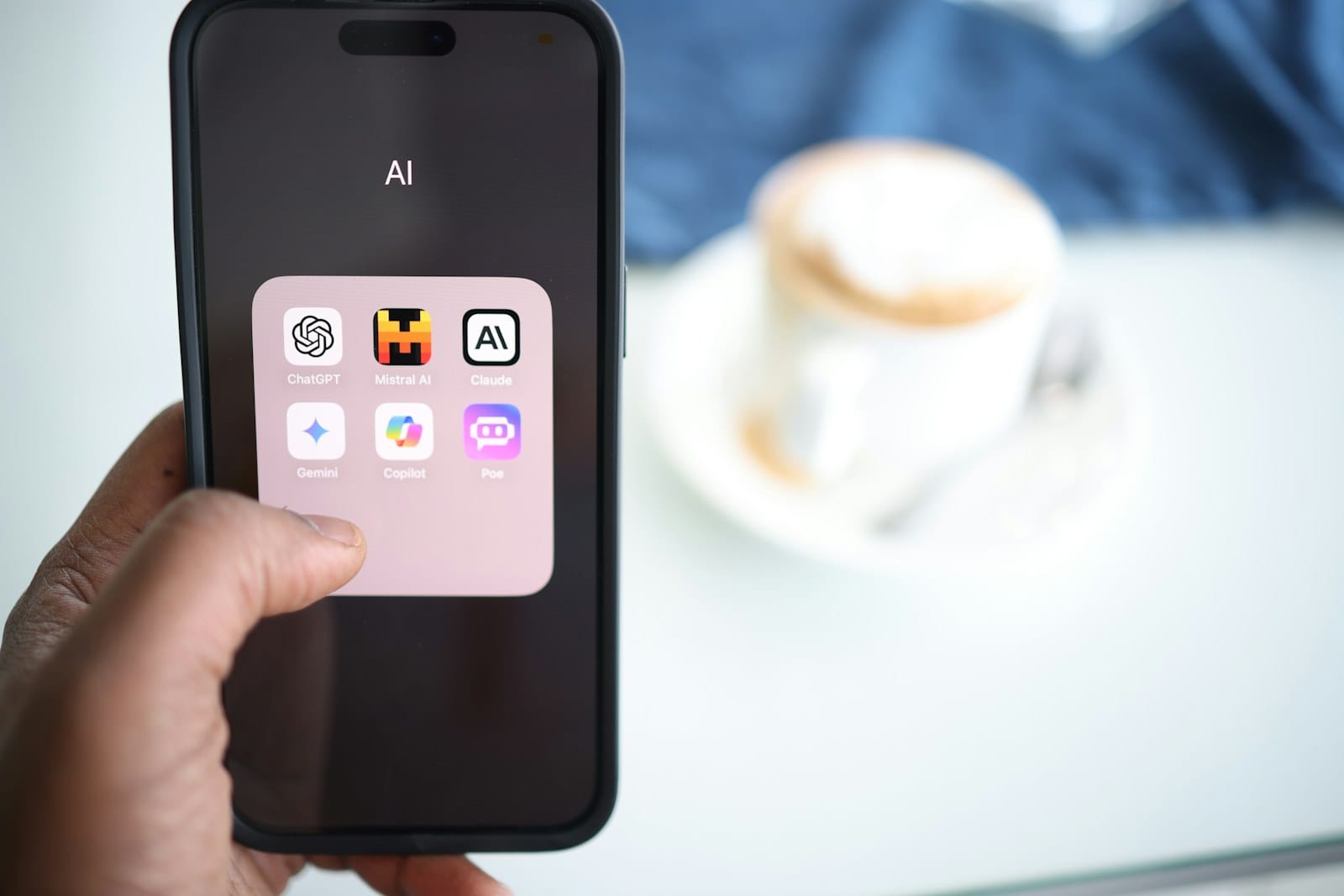 A hand holding a phone showing an AI assistant.